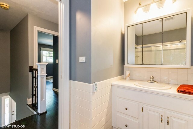 bathroom featuring vanity, tile walls, and wainscoting