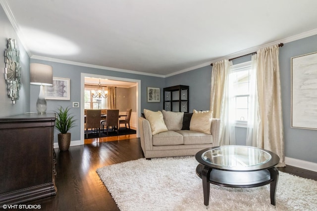 living area with a chandelier, dark wood-style flooring, crown molding, and baseboards