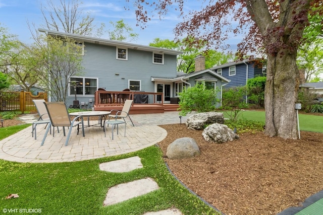 rear view of house featuring a patio, a deck, and a chimney