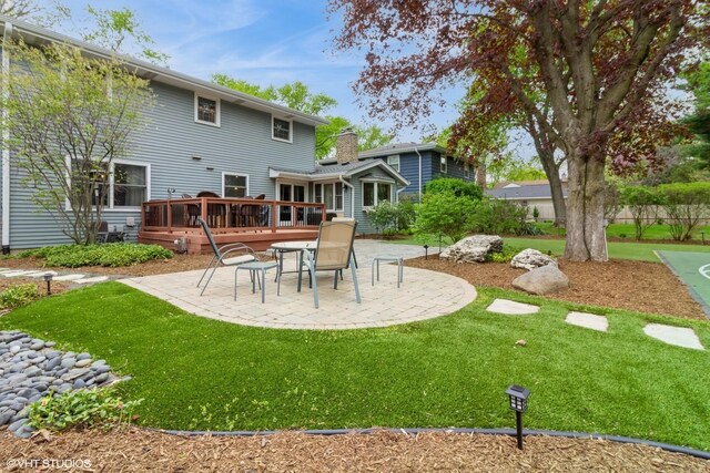 back of property featuring a patio, a wooden deck, and a yard