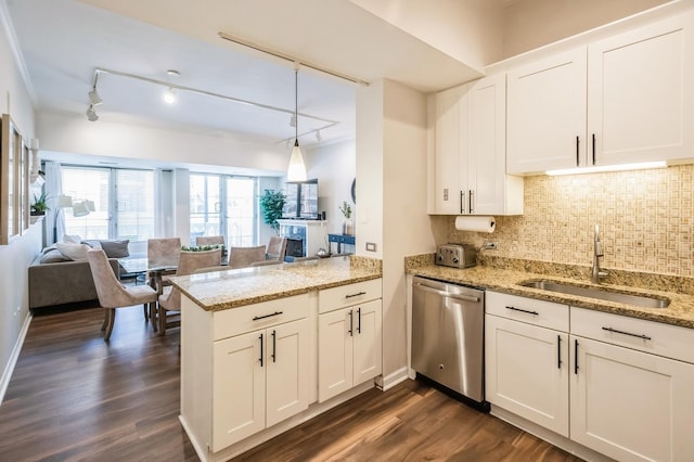 kitchen with dishwasher, a sink, a peninsula, open floor plan, and white cabinetry
