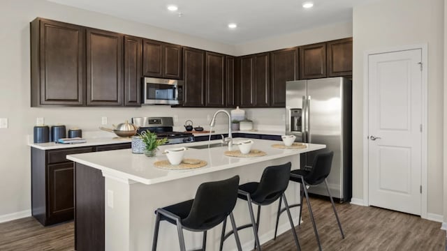 14739 Hillside Dr S, Lockport, IL 60441 - kitchen featuring stainless steel appliances, a sink, dark wood-style flooring, a kitchen breakfast bar, and recessed lighting