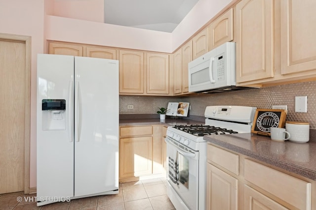 kitchen with white appliances, light brown cabinetry, and dark countertops