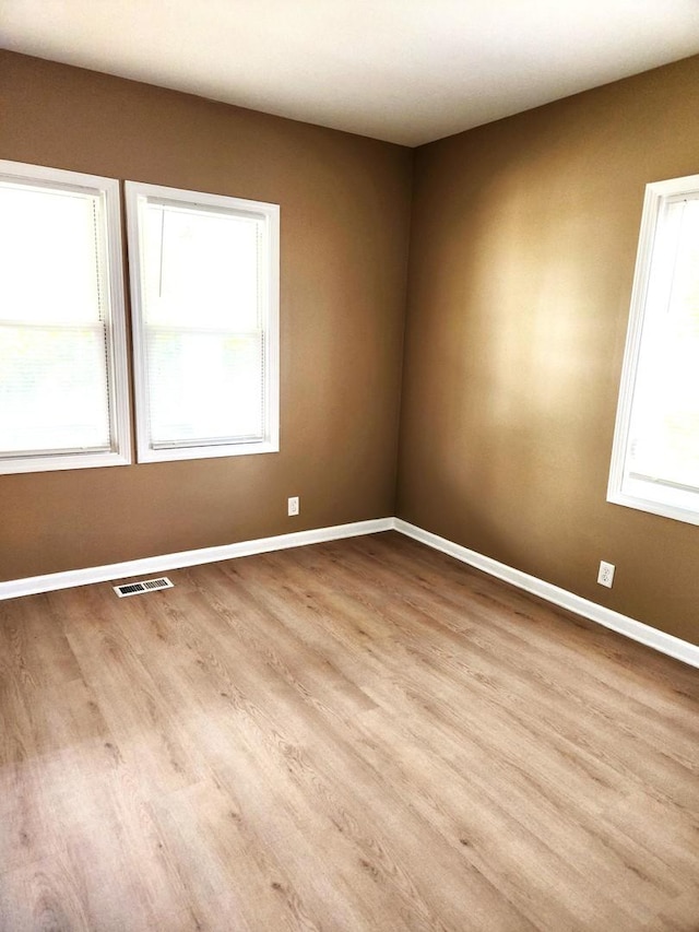 unfurnished room with wood finished floors and baseboards