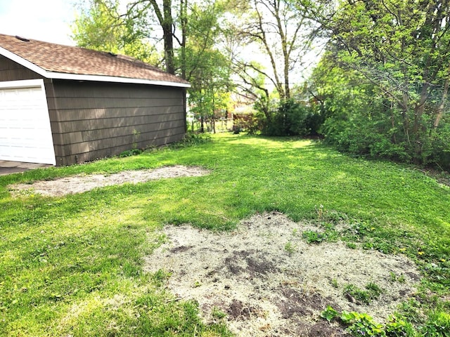 view of green lawn featuring a garage