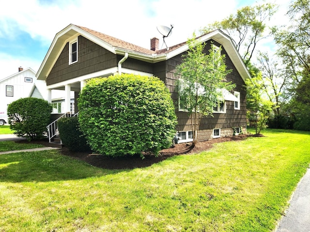 view of side of property featuring a yard and a chimney
