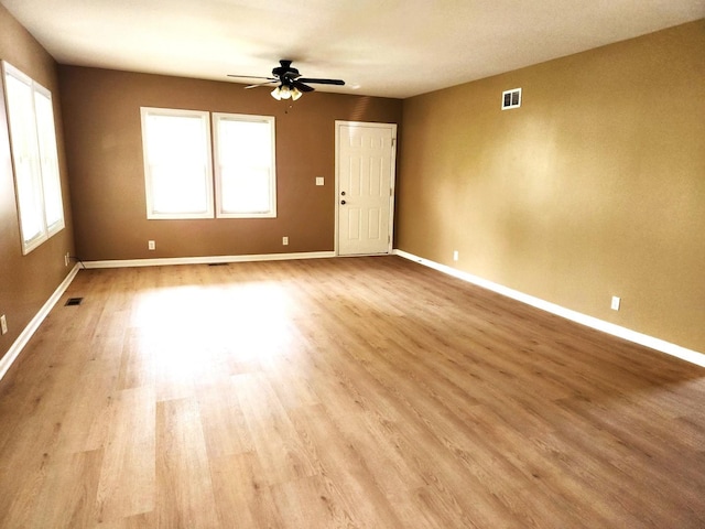 unfurnished room featuring wood finished floors, ceiling fan, and baseboards