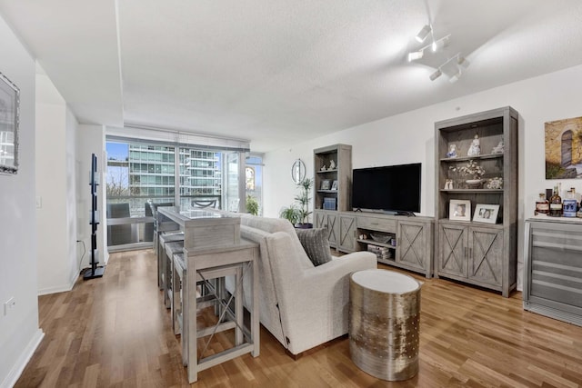 9725 Woods Dr Unit 507, Skokie, IL 60077 - living room with wood finished floors, wine cooler, baseboards, a textured ceiling, and floor to ceiling windows