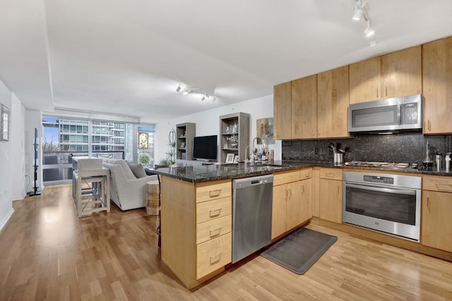 9725 Woods Dr Unit 507, Skokie, IL 60077 - kitchen with stainless steel appliances, track lighting, light brown cabinetry, open floor plan, and a peninsula