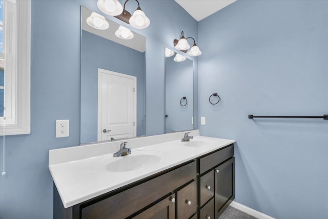 full bath featuring double vanity and baseboards