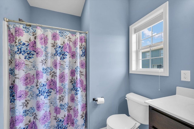 bathroom with vanity, toilet, and curtained shower
