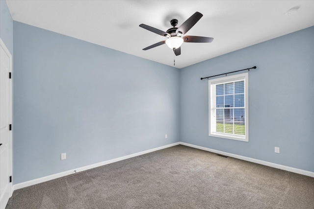 carpeted empty room with ceiling fan, baseboards, and a smoke detector
