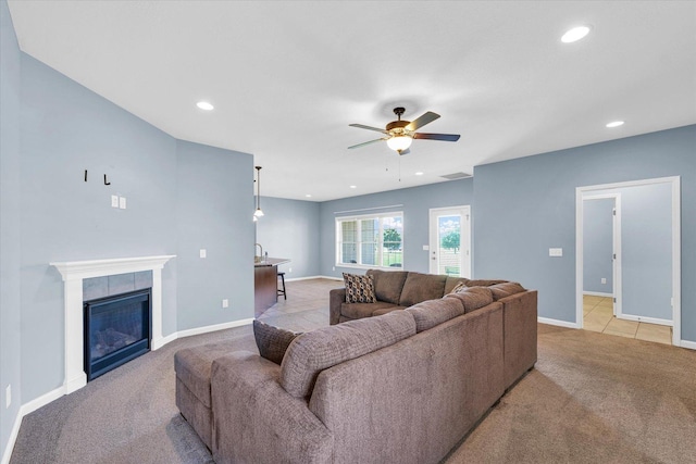 living area featuring light carpet, a ceiling fan, baseboards, recessed lighting, and a fireplace