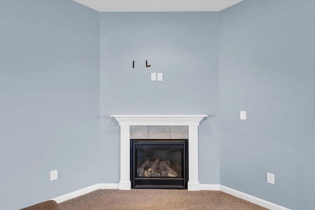 detailed view of carpet, a glass covered fireplace, and baseboards