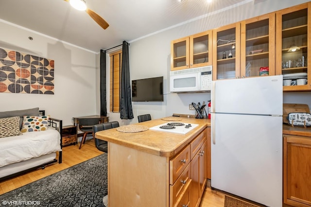 kitchen with white appliances, light wood finished floors, a ceiling fan, glass insert cabinets, and light countertops