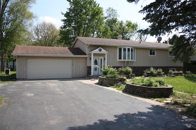 view of front facade featuring a chimney, asphalt driveway, a garage, a shingled roof, and a front lawn