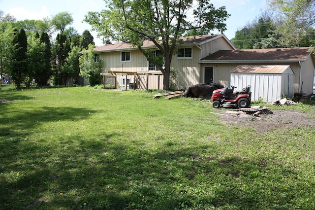 view of grassy yard featuring a storage shed and an outbuilding