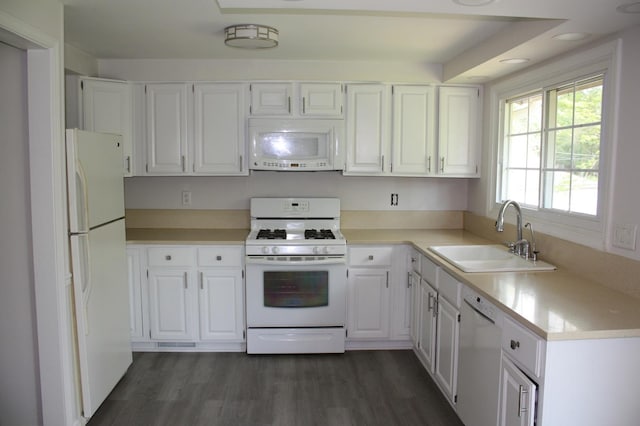 kitchen featuring white appliances, a sink, white cabinets, and dark wood finished floors
