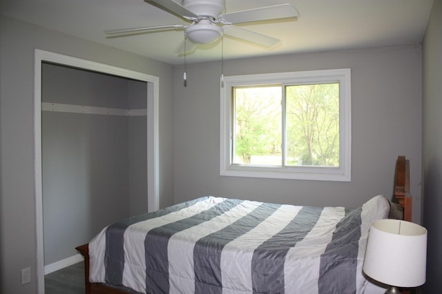 bedroom featuring baseboards, ceiling fan, wood finished floors, and a closet