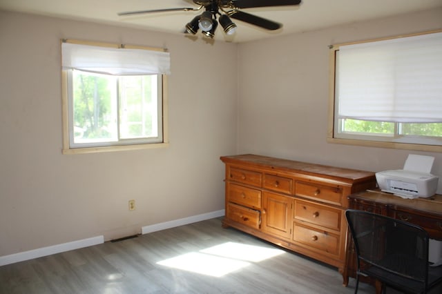 office area featuring healthy amount of natural light, light wood-type flooring, ceiling fan, and baseboards