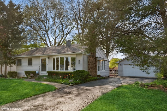 ranch-style home featuring an outbuilding, a front lawn, a chimney, a garage, and entry steps