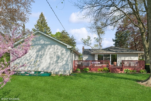 rear view of house with a lawn and a wooden deck