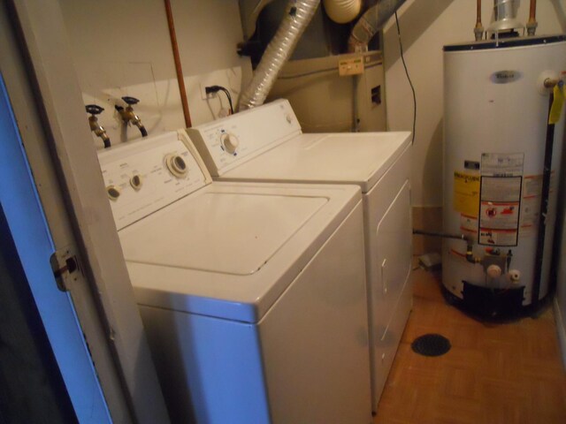 clothes washing area featuring water heater and separate washer and dryer