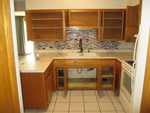 kitchen with white range with electric cooktop, a sink, open shelves, brown cabinets, and light countertops