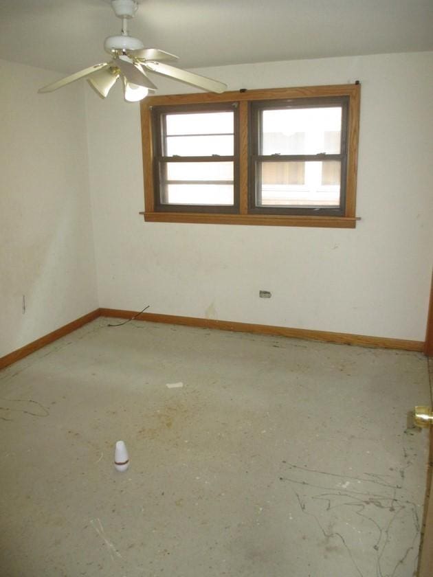 unfurnished room with plenty of natural light, baseboards, and ceiling fan