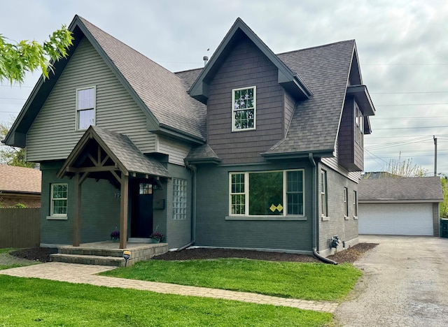 view of front of property featuring a shingled roof, an outbuilding, brick siding, and a garage