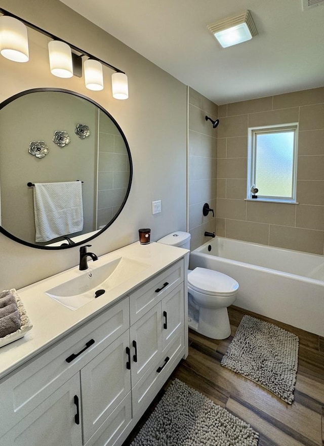 bathroom with wood finished floors, shower / bathtub combination, vanity, and toilet