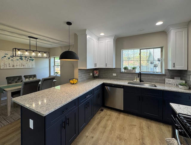 kitchen featuring stainless steel dishwasher, a sink, light wood-style floors, white cabinets, and recessed lighting
