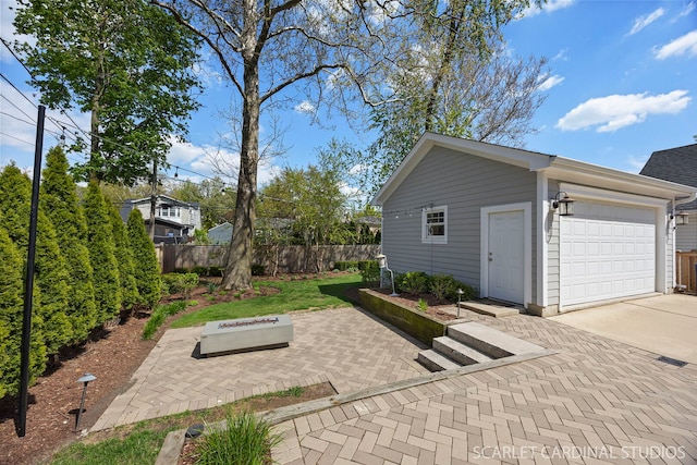 garage featuring fence and driveway