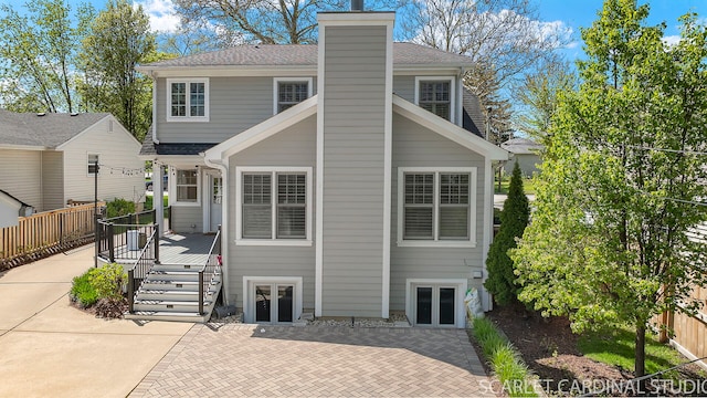 back of house featuring french doors, fence, a chimney, a patio area, and a shingled roof