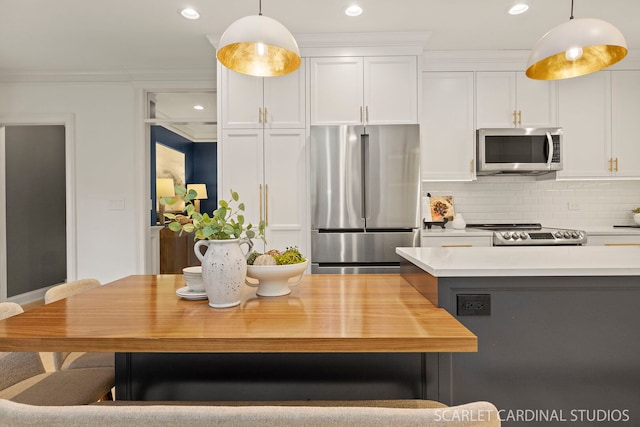 kitchen with stainless steel appliances, light countertops, white cabinets, recessed lighting, and pendant lighting