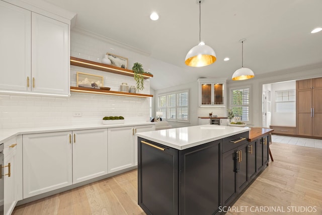kitchen with white cabinetry, light wood-type flooring, light countertops, recessed lighting, and ornamental molding