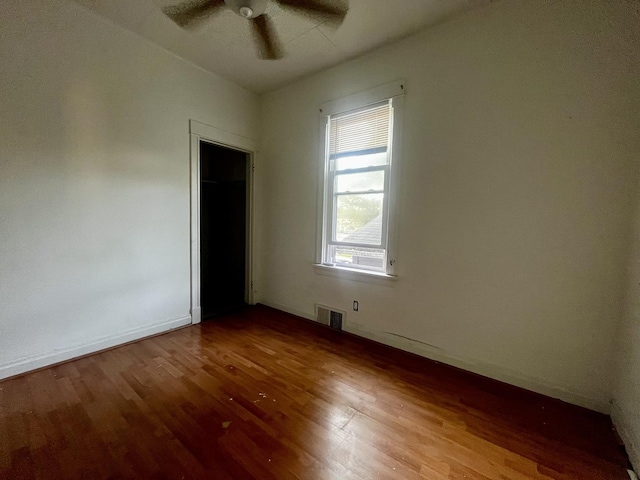 unfurnished bedroom featuring wood finished floors, a ceiling fan, and baseboards