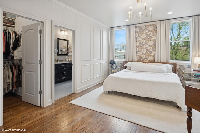 1319 N Oakley Blvd, Chicago, IL 60622 - bedroom featuring a spacious closet, a chandelier, multiple windows, crown molding, and wood finished floors