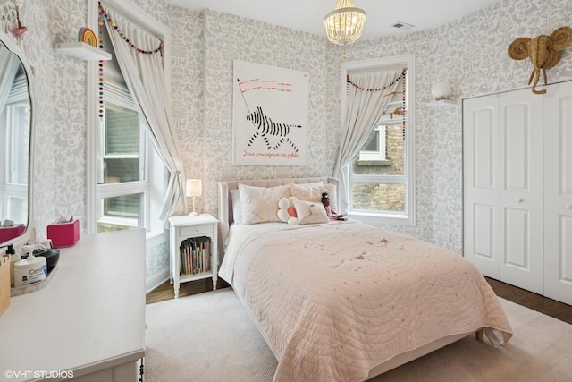 1319 N Oakley Blvd, Chicago, IL 60622 - bedroom with wallpapered walls, a chandelier, multiple windows, wood finished floors, and a closet