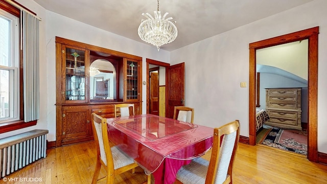 3072 N Haussen Ct, Chicago, IL 60618 - dining area with radiator heating unit, a chandelier, light wood finished floors, and baseboards