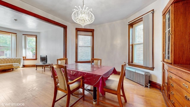 3072 N Haussen Ct, Chicago, IL 60618 - dining area with radiator heating unit, light wood-style flooring, baseboards, and a chandelier