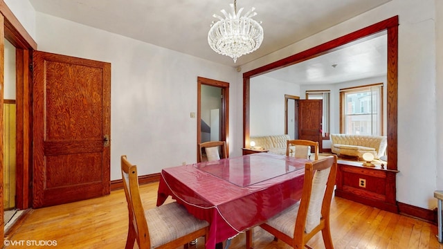 3072 N Haussen Ct, Chicago, IL 60618 - dining area featuring light wood finished floors, a chandelier, and baseboards