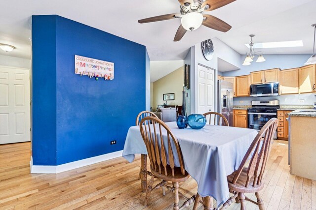 dining space with lofted ceiling, light wood-style floors, baseboards, and a ceiling fan