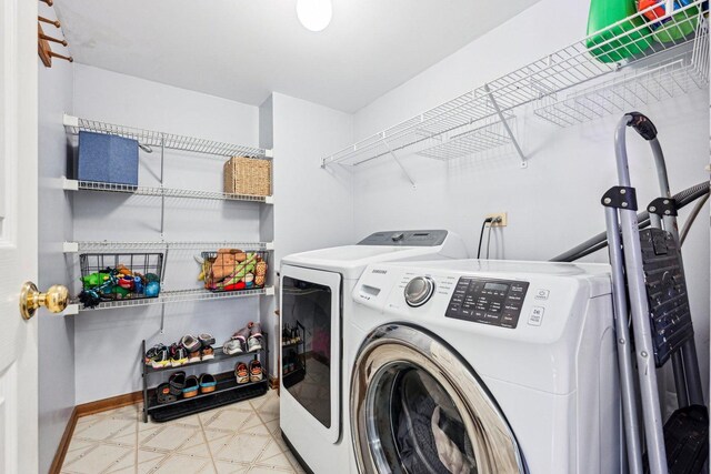 clothes washing area featuring washer and dryer, baseboards, and tile patterned floors
