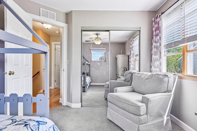 carpeted bedroom featuring baseboards and a closet