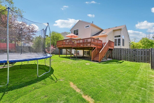 rear view of house featuring a trampoline, a deck, and stairway