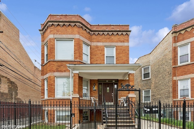 2416 N Avers Ave, Chicago, IL 60647 - view of front of home with brick siding, a fenced front yard, covered porch, and a gate