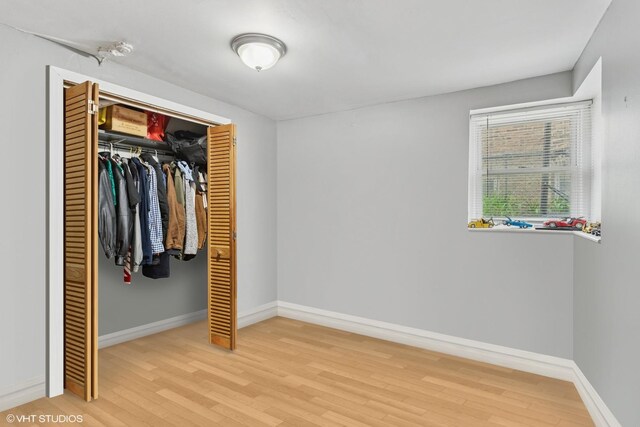 2416 N Avers Ave, Chicago, IL 60647 - unfurnished bedroom featuring wood finished floors, a closet, and baseboards