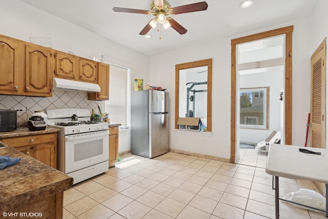 2416 N Avers Ave, Chicago, IL 60647 - kitchen with freestanding refrigerator, white gas range, under cabinet range hood, backsplash, and ceiling fan