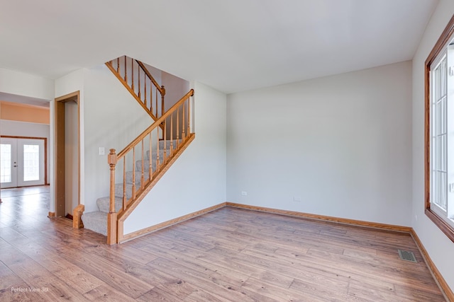 2675 Dorothy Dr, Aurora, IL 60504 - unfurnished living room with stairs, light wood-type flooring, baseboards, and french doors